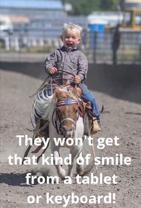 Boy riding a pony and smiling.