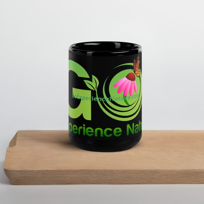 Black mug with green and pink nature design.